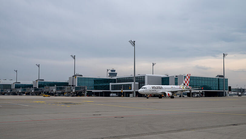 Ein Flugzeug f&auml;hrt am Au&szlig;enbereich des Erweiterungsbau des Terminals 1 am M&uuml;nchner Flughafen vorbei. Der Neubau erm&ouml;glicht Kapazit&auml;ten f&uuml;r bis zu sechs Millionen Passagiere pro Jahr. Eine dritte Startbahn wird derzeit aber nicht gebaut.