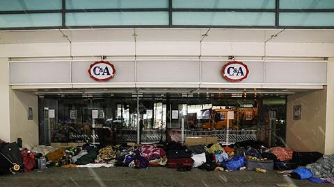 Obdachlose Menschen haben ihren Schlafplatz im Eingang eines Kaufhauses in der Innenstadt aufgeschlagen.
