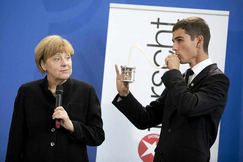 Beeindruckt oder irritiert? Bundeskanzlerin Angela Merkel und der Gewinner des Sonderpreises des Wettbewerbs "Jugend forscht".