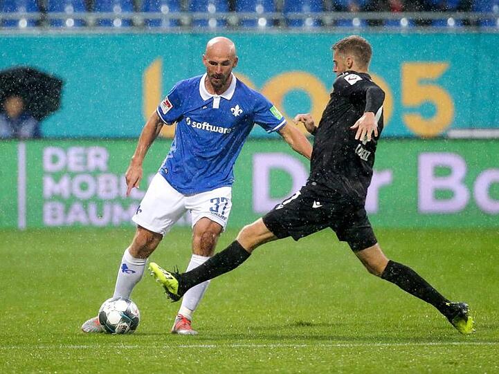 Der Darmstädter Patrick Herrmann (l) im Zweikampf mit Marc Lorenz vom Karlsruher SC.