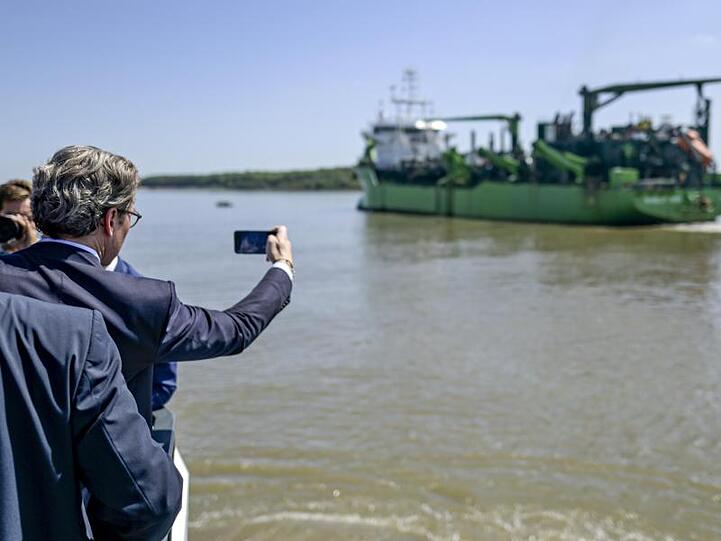 Bundesverkehrsminister Andreas Scheuer (CSU) fotografiert den Hopperbagger "Scheldt River".