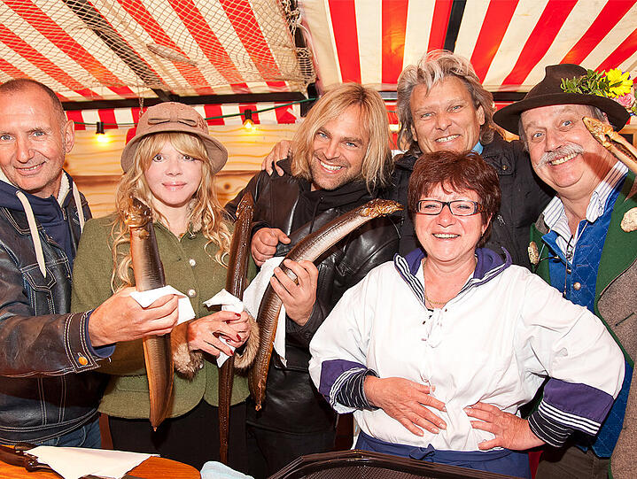 Zum Anbeißen (v. l.): &bdquo;Münchener Freiheit&ldquo;-Keyborder Alex Grünwald, PR-Lady Simone Petrov, Leadsänger Tim Wilhelm, Schauspieler Ernst Hannawald und Maler Wolfgang M. Prinz mit Marktfrau Gretel am Fischmarkt.