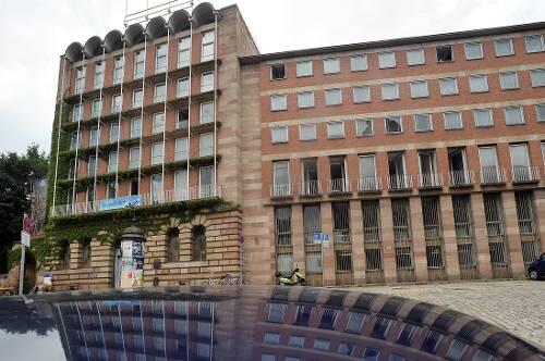 Das neue Pellerhaus aus dem Jahr 1957 ist selbst schon ein Baudenkmal. Die Fassade mit den vier Fahnenmasten spiegelt sich im Dach eines parkenden Autos.