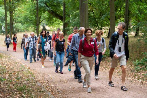 Eckhard Linner (r.), Firmengründer des Unternehmens &bdquo;WanderDate&ldquo; läuft mit Teilnehmern einer Singlewanderung durch den Landschaftsgarten Rosenhöhe.