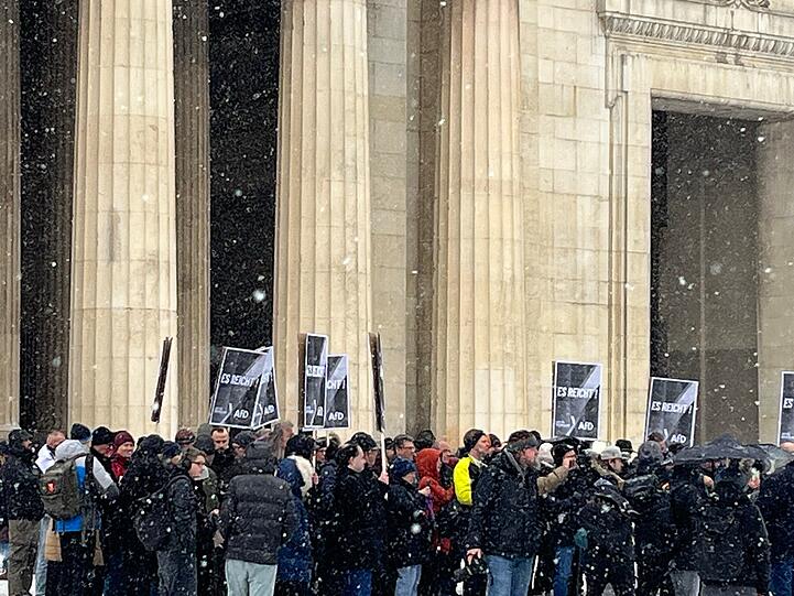 Die AfD-Demonstration zählt laut Polizei ca. 70 Teilnehmende.  Sie halten Schilder hoch mit der Aufschrift "Es reicht. AfD"