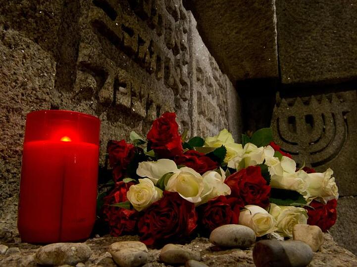 Kerzen, Rosen und Kieselsteine an der Stelle der ehemaligen Hauptsynagoge in München. Foto: Peter Kneffel/dpa/Archivbild
