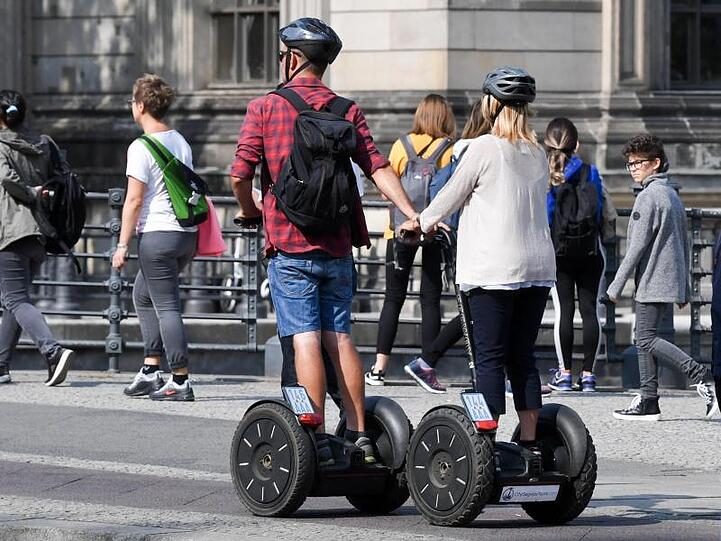 Touristen fahren mit Segways durch Berlin-Mitte.