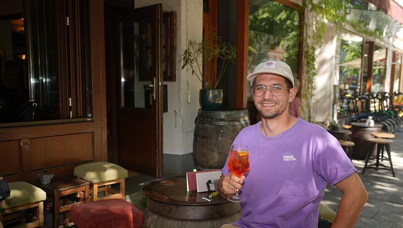 Mitarbeiter Marius mit Aperol Spritz vor dem Lollo Rosso.
