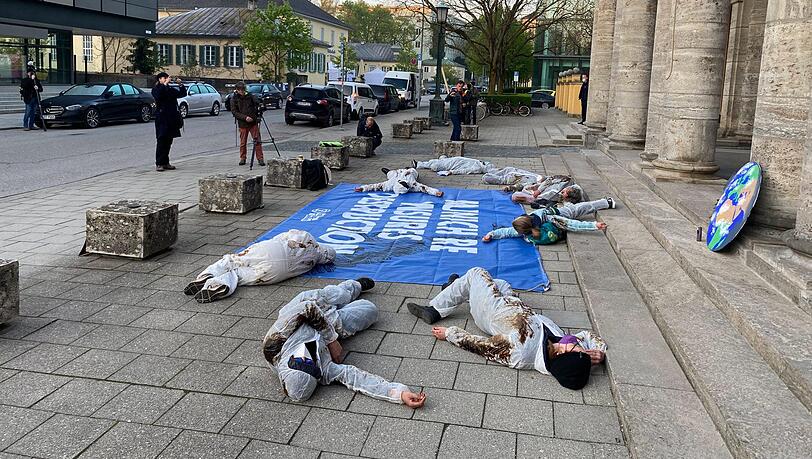 Aktivisten stellen sich vor dem Gebäude tot. Aktivisten stellen sich vor dem Gebäude tot.