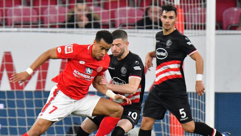 Der Mainzer Robin Quaison (l) versucht sich gegen die Düsseldorfer Valon Berisha und Kaan Ayhan durchzusetzen. Der Mainzer Robin Quaison (l) versucht sich gegen die Düsseldorfer Valon Berisha und Kaan Ayhan durchzusetzen.