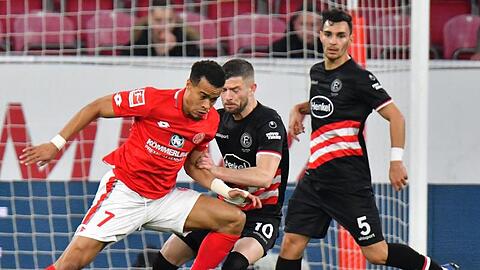 Der Mainzer Robin Quaison (l) versucht sich gegen die Düsseldorfer Valon Berisha und Kaan Ayhan durchzusetzen.