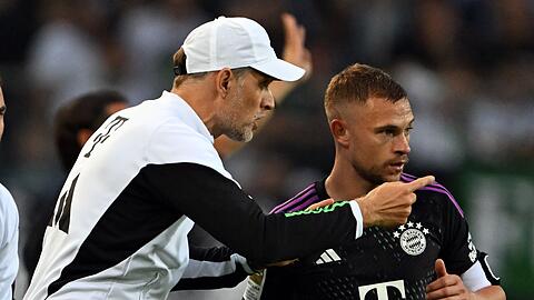 Bayerns Trainer Thomas Tuchel (l) gibt Joshua Kimmich Anweisungen.