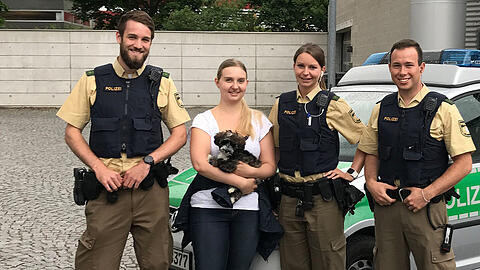 Eingesetzte Polizeibeamte mit einem Mitglied des Tierschutzvereins und dem Welpen Hugo