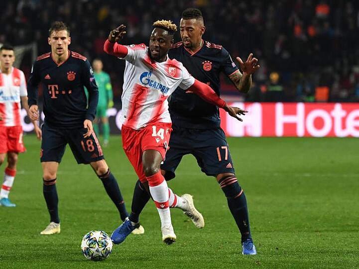 Belgrads Richmond Boakye (M.) und Münchens Jérôme Boateng im Zweikampf um den Ball. Foto: Sven Hoppe/dpa