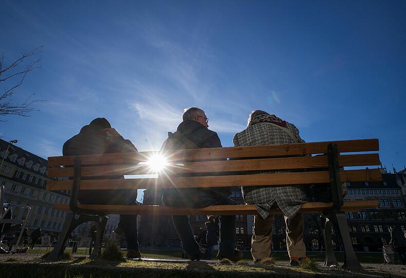 Das Wetter beherrscht den Dezember eh: in München genießen Passanten die Sonne im Marienhof...