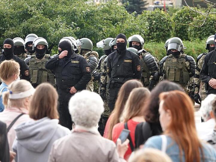 Demonstranten und Einsatzkräfte der Sonderpolizei OMON stehen sich am Unabhängigkeitsplatz in Minsk gegenüber.
