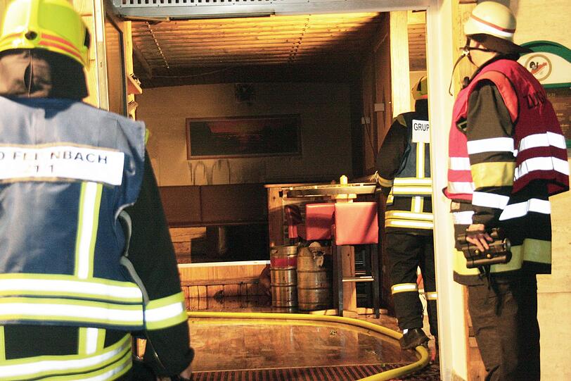 Feuerwehrmänner vor der "Haxn" in Bad Feilnbach: Sie können das Haus retten, die Wirtschaft aber wird durch den Brandstifter zerstört, der Schaden beträgt rund 80.000 Euro.