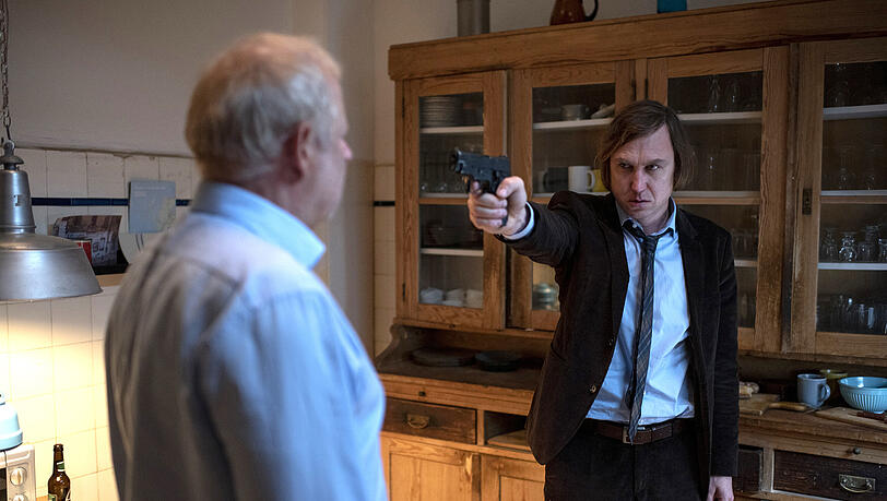 Unberechenbar: Kai (Lars Eidinger, re.) zielt auf Borowski (Axel Milberg, li.) in einer Szene aus "Tatort: Borowski und der gute Mensch"