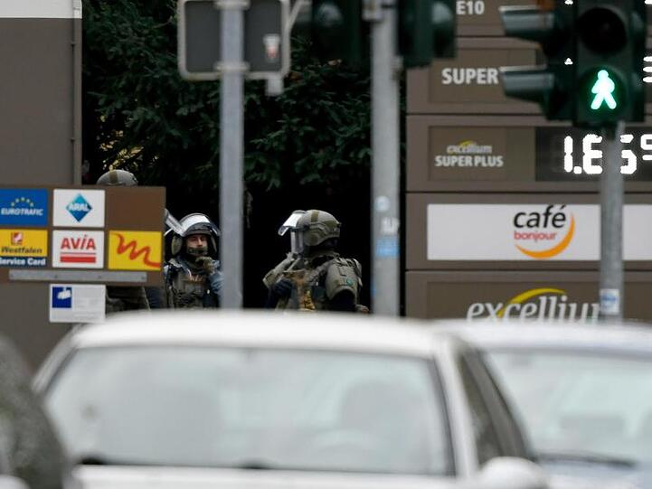 Schwer bewaffnete Polizisten stehen an einer Tankstelle im Bochumer Stadtteil Langendreer.