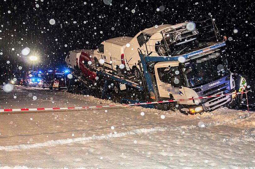 Ein Autotransporter rutscht aufgrund der schneeglatten Fahrbahn in den Graben