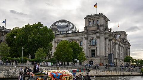 Demonstranten fahren mit einem Boot am Berliner Reichstagsgebäude vorbei. Das Klimapaket der Bundesregierung wird von Opposition, Umweltschützern und Wirtschaftsverbänden weiter scharf kritisiert.