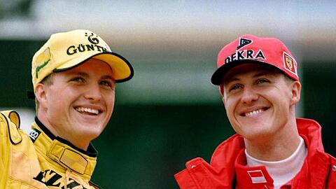 Die Brüder Michael Schumacher (r., Ferrari) und Ralf Schumacher (Jordan) winken nach dem Großen Preis von Deutschland auf dem Hockenheimring den Zuschauern zu.