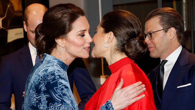 Prinzessin Kate und die schwedische Kronprinzessin Victoria 2018 in Stockholm. Rechts Victorias Mann, Prinz Daniel, im Hintergrund Prinz William.