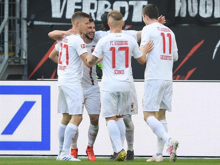 Die Augsburger Finnbogason (l-r), Richter, Schmid und Gregoritsch jubeln. Augsburg hat die Partie in Frankfurt gedreht.