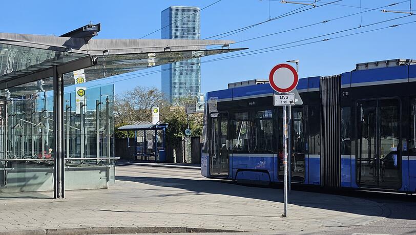 Tramstation mit Hochhaus- und Olympiaturm-Blick. Im Hintergrund der Eingang zur Kleingartenanlage.