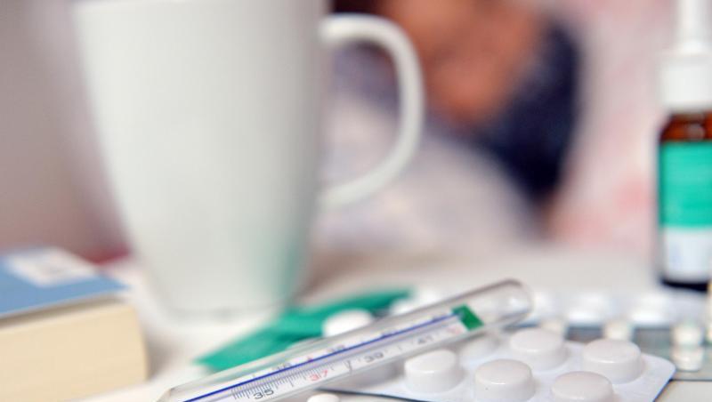 Medikamente und ein Fieberthermometer liegen auf einem Nachttisch. Medikamente und ein Fieberthermometer liegen auf einem Nachttisch.