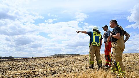 Einsatzkräfte der Feuerwehr begutachten die Brandstelle.