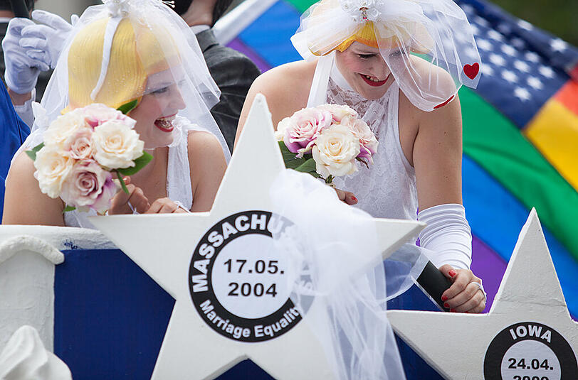 CSD-Teilnehmer fahren auf einem Wagen durch die Straßen Berlins.