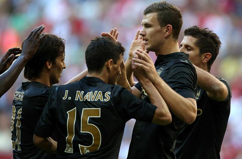 Edin Dzeko, dreifacher Torschütze für Manchester City zur Halbzeit jubelt mit Jesus Navas und David Silva.