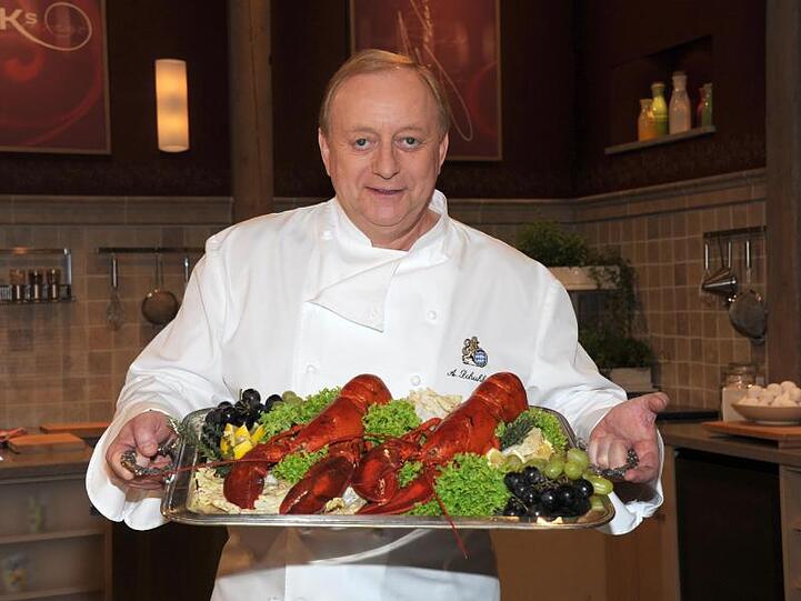 Alfons Schuhbeck hält ein Tablett mit Essen. Foto: Ursula Düren/dpa/Archivbild