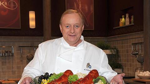Alfons Schuhbeck hält ein Tablett mit Essen. Foto: Ursula Düren/dpa/Archivbild