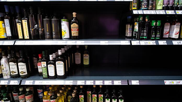 Flaschen mit Öl stehen in einem Regal in einem Supermarkt.