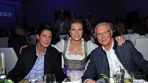 Fußball-Legende Franz Beckenbauer (r), die ehemalige Skirennläuferin Maria Höfl-Riesch und ihr Mann Marcus Höfl bei einer Gala.