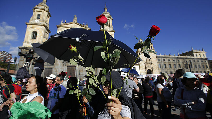 Anhänger der früheren Guerillaorganisation Farc halten in Bogota beim Parteikongress rote Rosen in den Händen. Nach über einem halben Jahrhundert im Untergrund verwandelt sich die Farc in eine politische Bewegung. Foto: Fernando Vergara