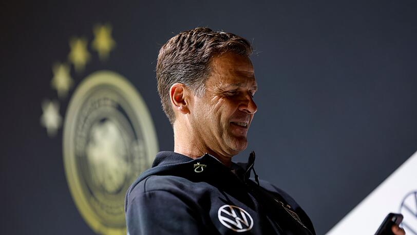 Oliver Bierhoff, Geschäftsführer Nationalmannschaften des DFB, schaut nach der Pressekonferenz auf sein Handy.