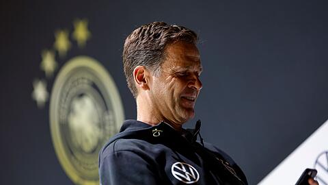 Oliver Bierhoff, Geschäftsführer Nationalmannschaften des DFB, schaut nach der Pressekonferenz auf sein Handy.