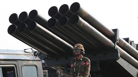 Ein Offizier steht während einer Militärparade auf einem mit Raketen beladenen Lastwagen.
