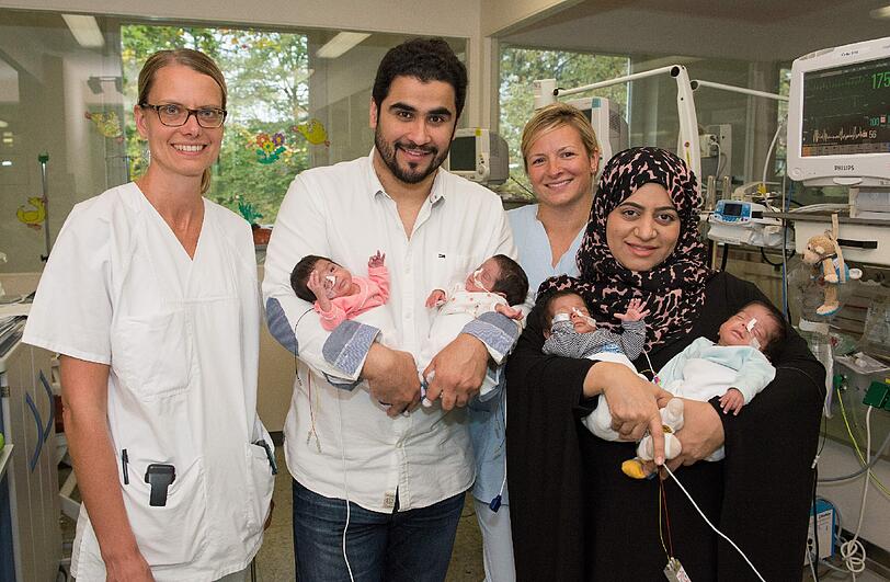 Oberärztin Dr. Rahel Schuler (links) und Kinderkrankenpflegerin Emilija Jentzsch freuen sich mit den Eltern über die Vierlinge.