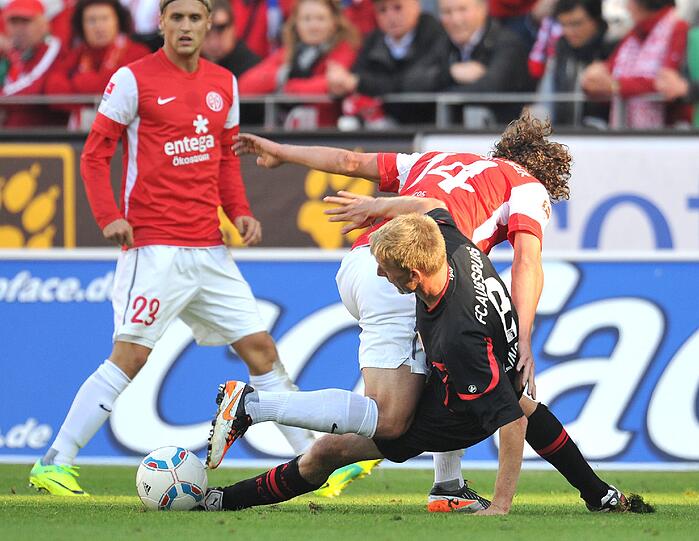 Der Mainzer Julian Baumgartlinger (r.) spielt gegen Augsburgs Axel Bellinghausen.