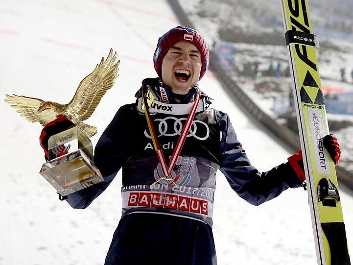 Kamil Stoch jubelt mit der Trophäe für den Gesamtsieg bei der Vierschanzentournee, dem goldenen Adler. Foto: Georg Hochmuth/APA/Archiv