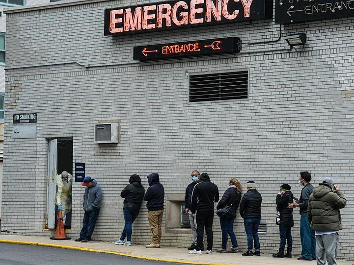 Menschen stehen vor einem Coronavirus-Testzentrum in New York Schlange.