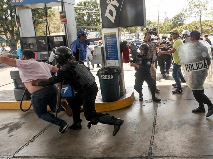 Polizisten gehen an einer Tankstelle in Managua gegen Demonstranten vor.