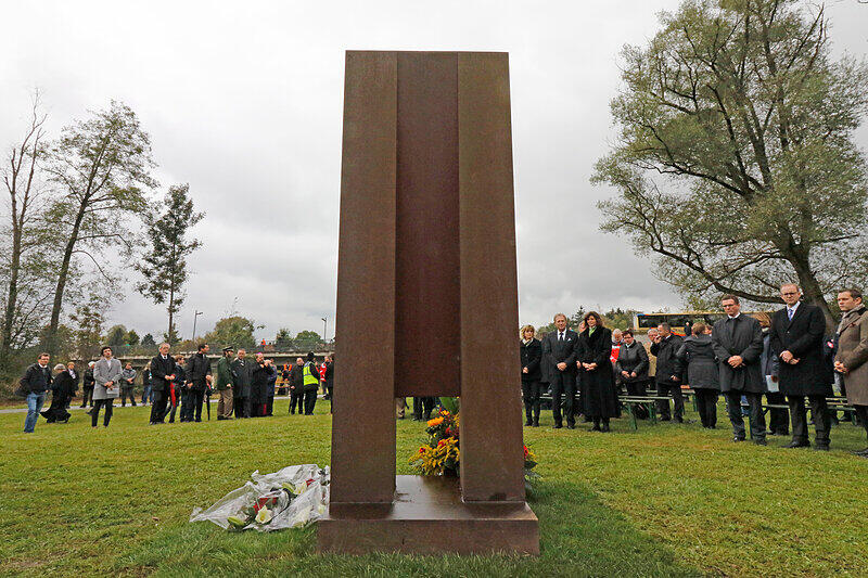 Teilnehmer der Feier stehen am 7.Oktober in Bad Aibling während der Einweihung einer Gedenkstätte für die Opfer des Zugunglücks. Zum 1. Jahrestag der Katastrophe findet dort eine ökumenische Andacht statt.