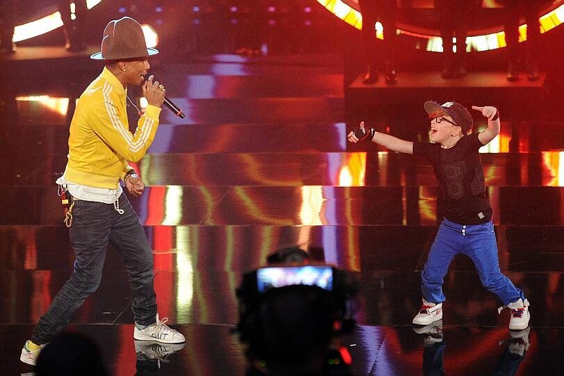 Musiker Pharrell Williams steht mit dem Kandidaten der Kinderwette, Leandro Palme, auf der Bühne.