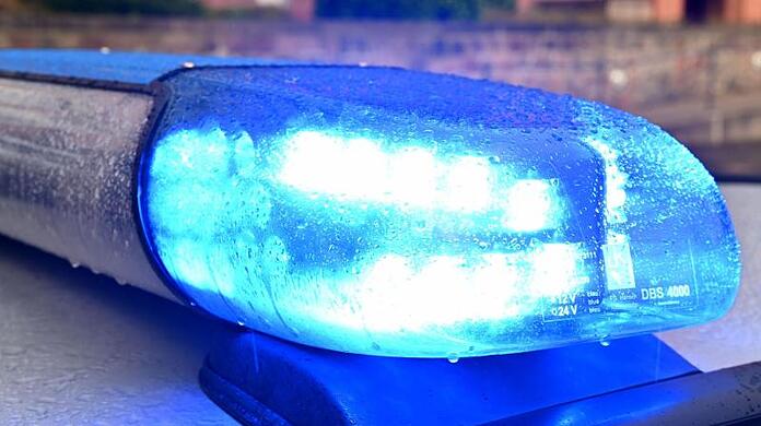Ein Streifenwagen der Polizei steht mit eingeschaltetem Blaulicht.