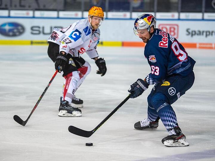 Maximilian Kastner (r) von Red Bull München spielt den Puck. Foto: Lino Mirgeler/dpa